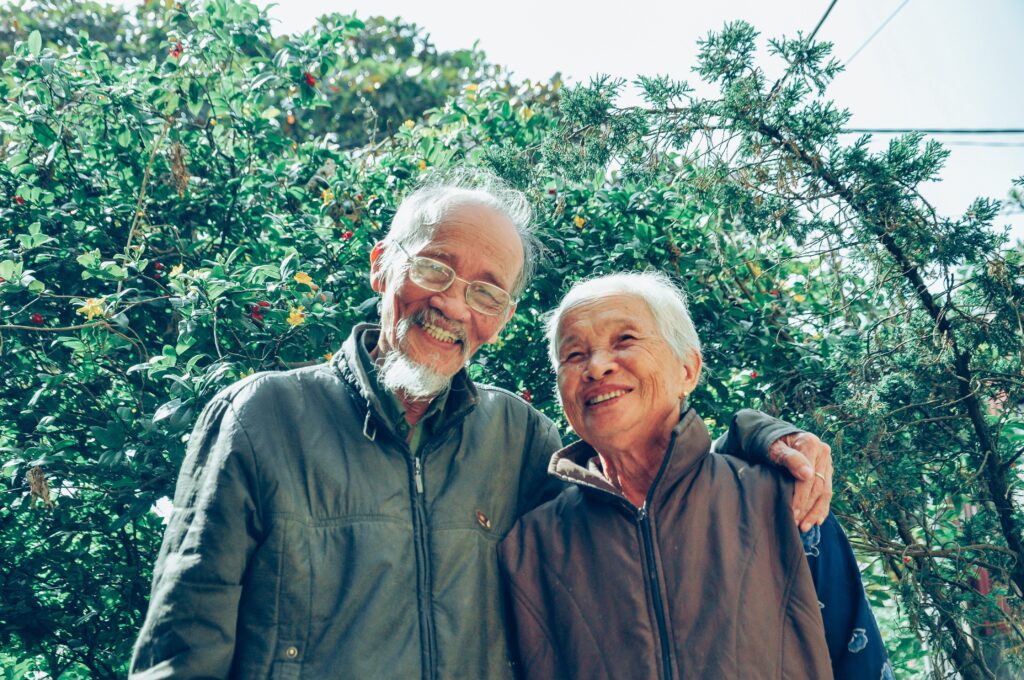 An old couple in front of a tree